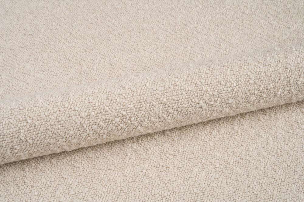 Mykt, beige møbelstoff lagt i folder